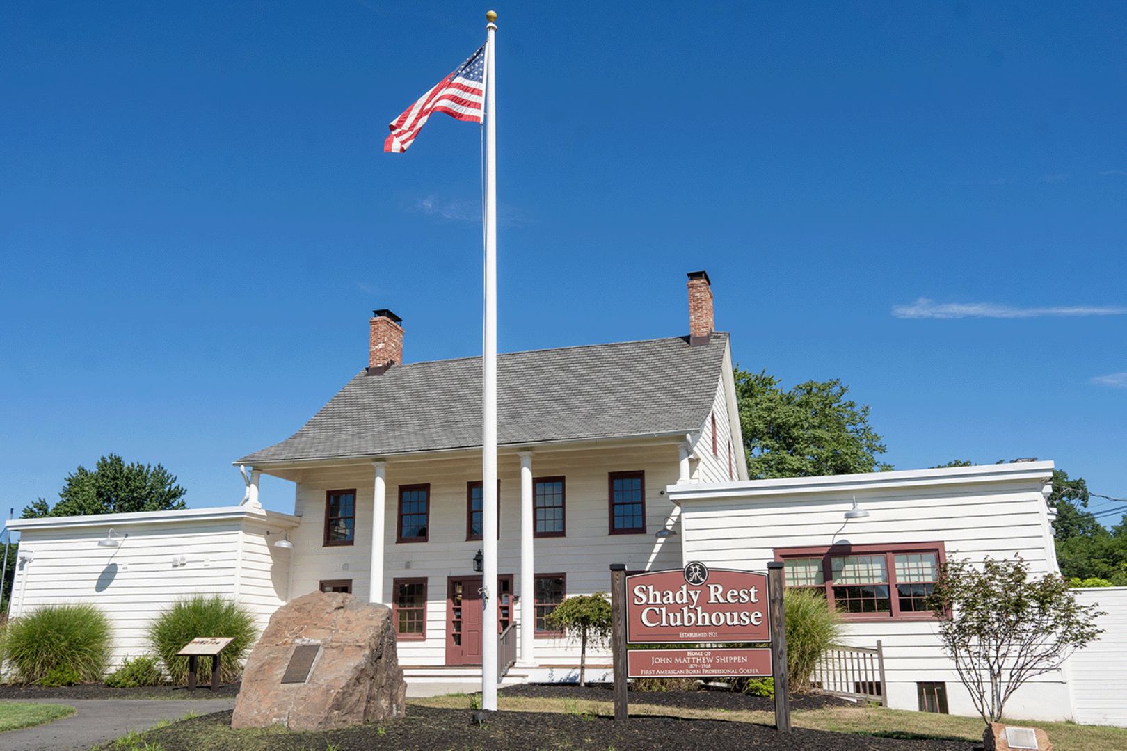 Photo of a building with a tall flagpole in front.