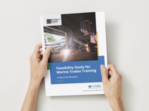 Hands holding a magazine against a white backdrop.